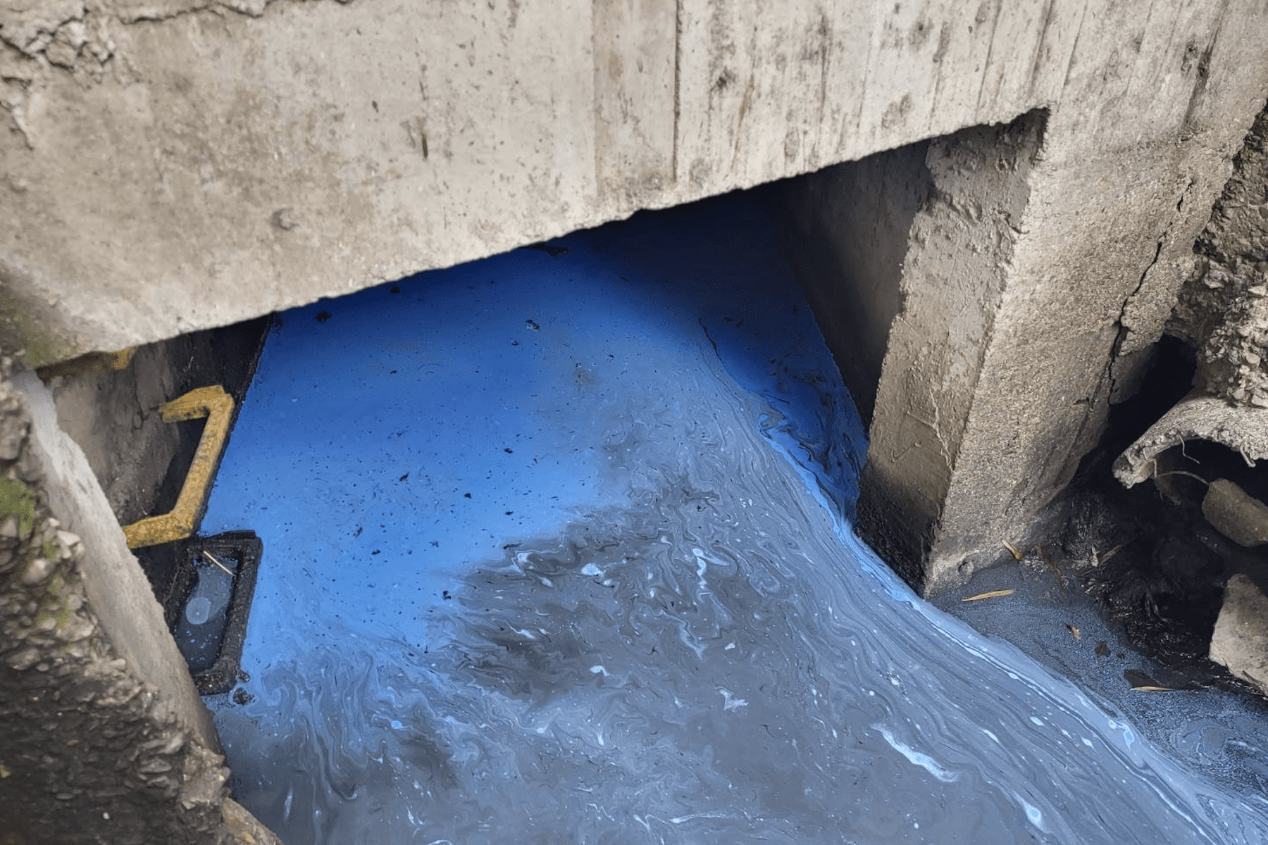 ▲藍色油漆倒入水溝污染溝渠。(圖/新北市環保局提供)