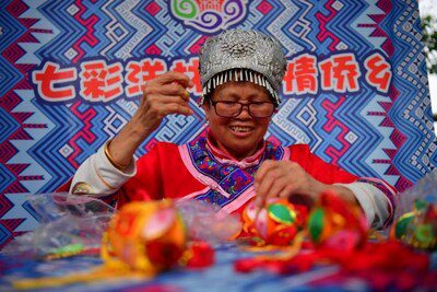 4月13日，江西省宜春市上高縣敖山鎮洋林歸僑少數民族聚居村的村民在製作特色香囊。(時雨 摄)