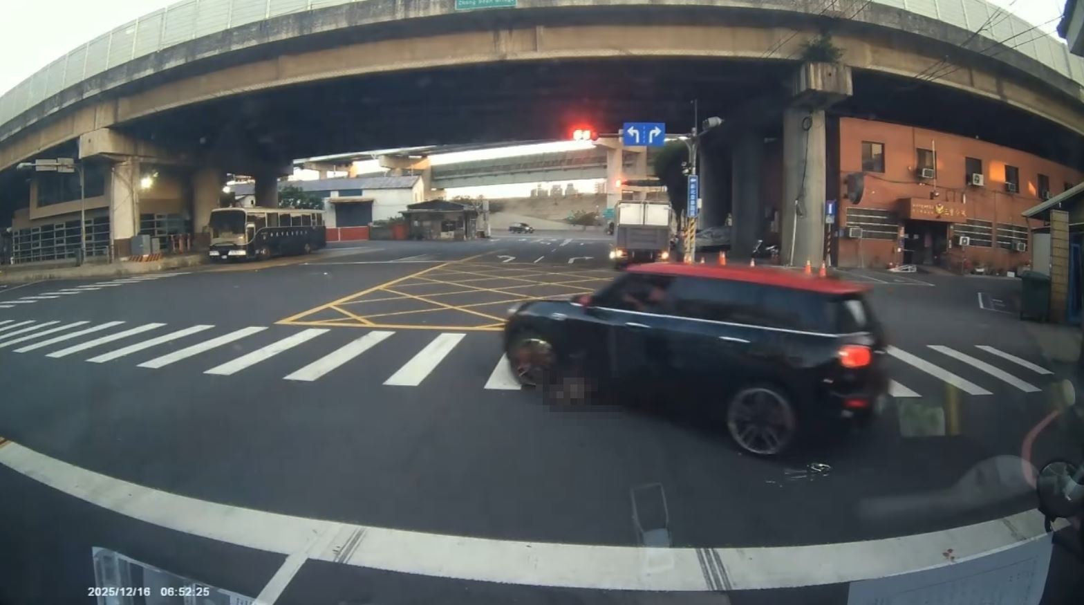 惡質駕駛違規於路口紅燈迴轉，儘管後方車輛不斷鳴按喇叭示警，駕駛仍踩油門加速前行，導致小黑狗先遭前輪捲入車底翻滾，隨即再被後輪二度輾過。