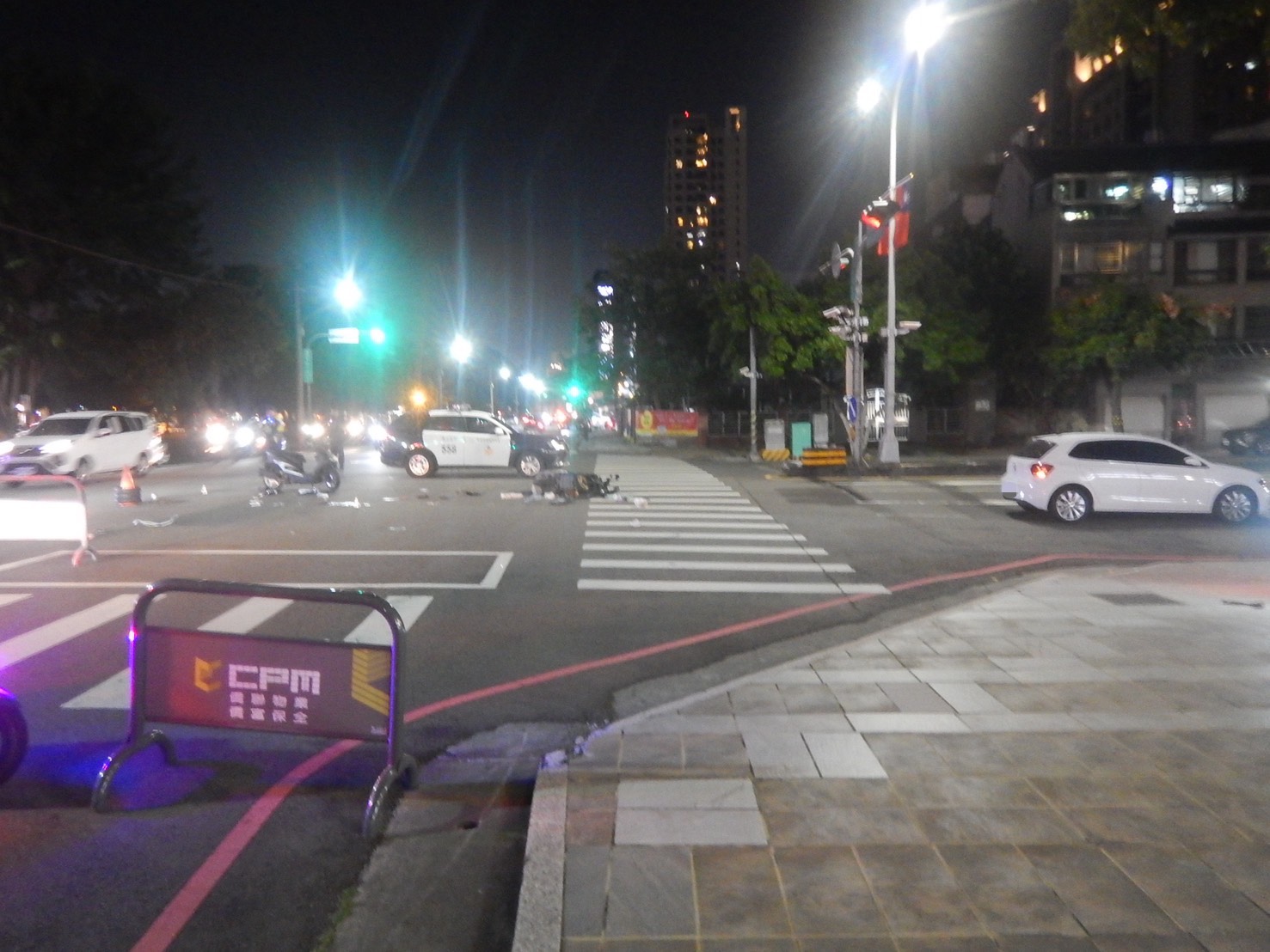 普重機車與相關物件散落路面，警方於現場勘查事故痕跡。