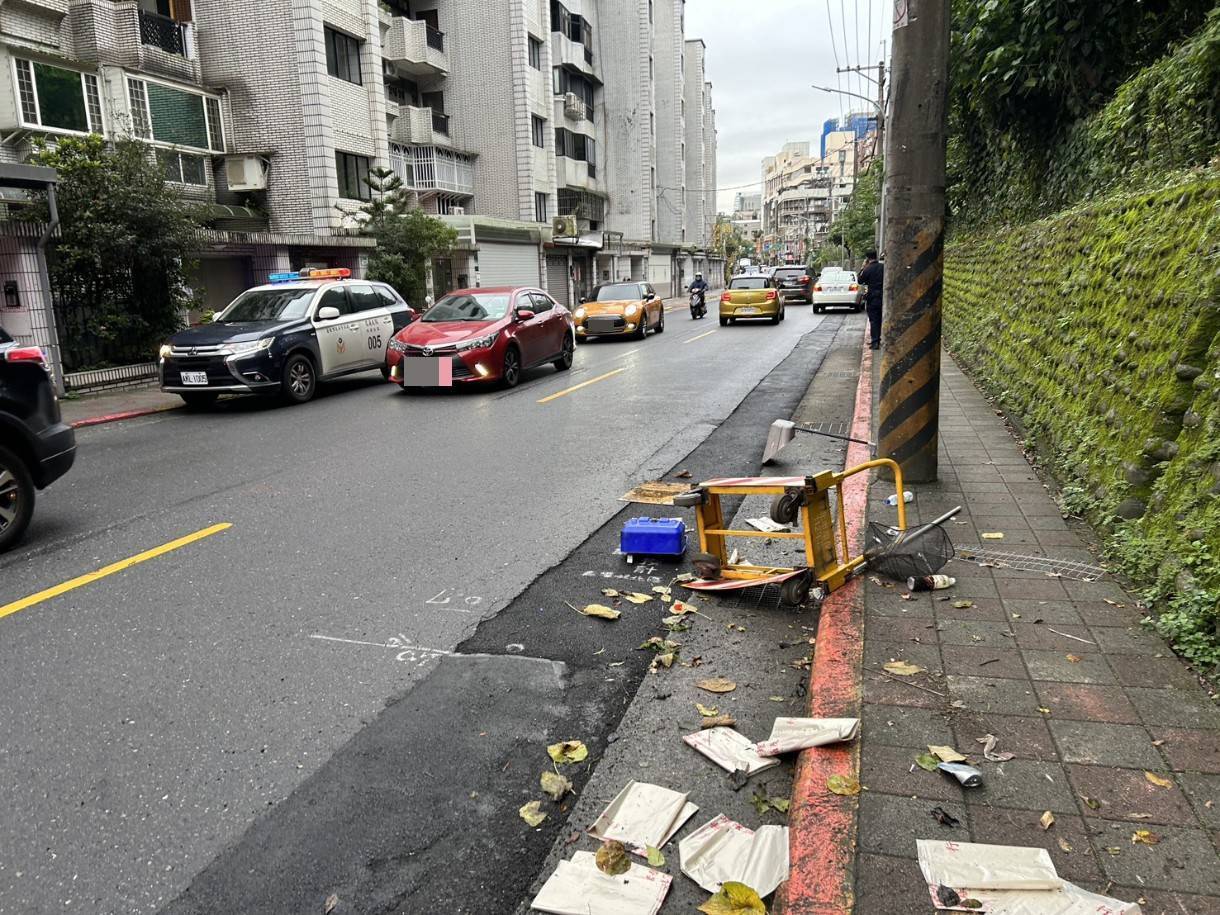 右前車頭直接撞飛路邊的清潔手推車,導致推車零件散落一地、鐵籃扭曲變形。