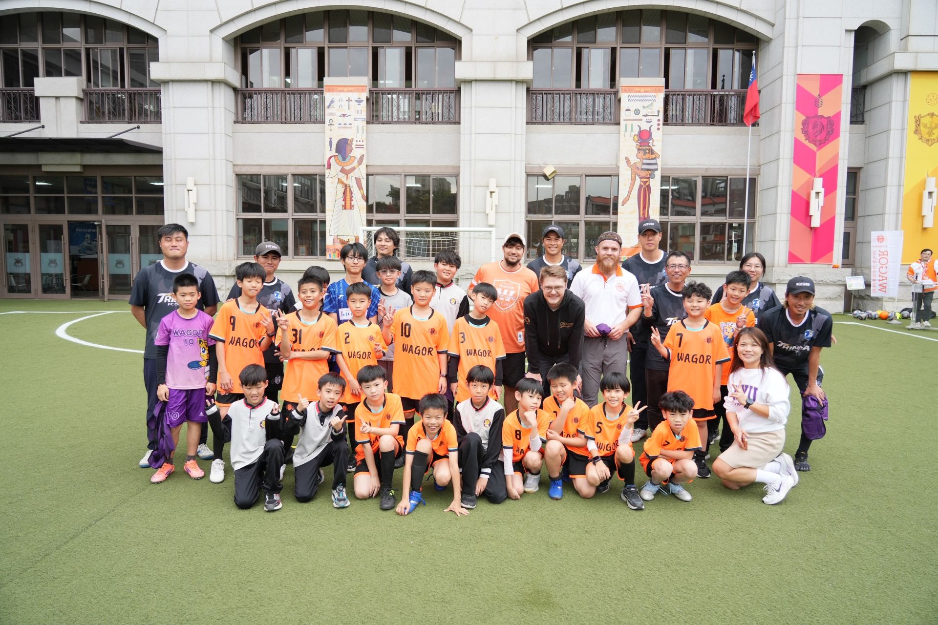 國際足球課程交流現場，學生與教練在校園球場熱血互動，氣氛熱烈。