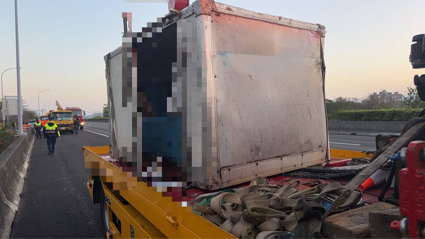 肇事小貨車經拖吊後移置路肩,車體嚴重變形,事故現場仍可見救援器材與拖吊設備。