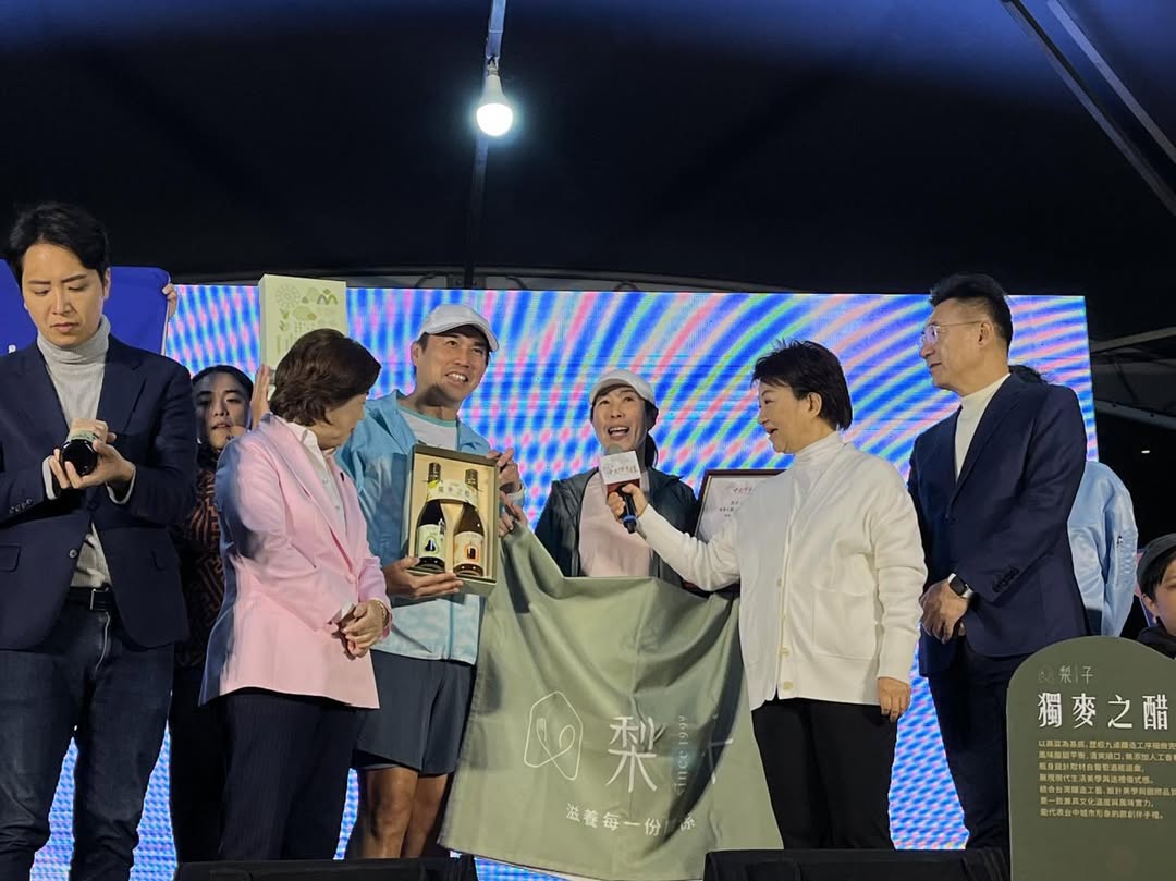 「2026第17屆台中市十大伴手禮」頒獎典禮現場，得獎業者代表展示獲獎商品，並於台上接受市長關心與簡短訪談，分享品牌理念與得獎心情，現場氣氛熱絡。