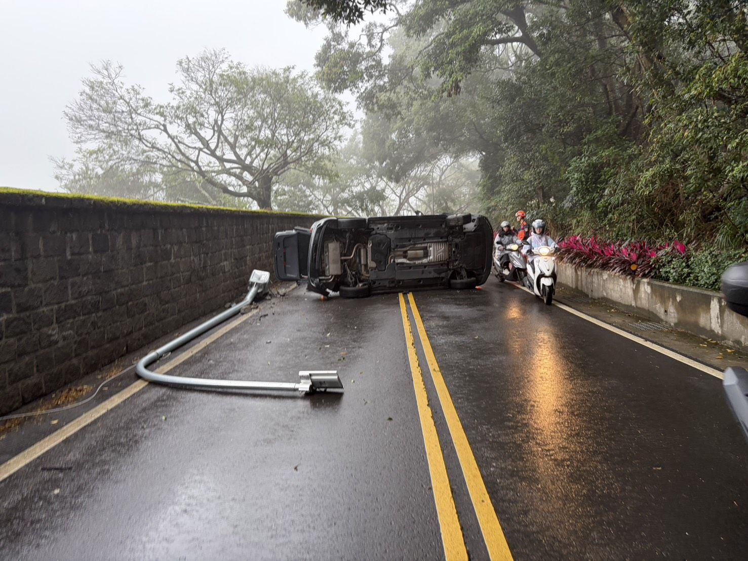 葉女車輛受撞擊後失去重心當場側翻,更順勢撞斷路旁路燈桿,造成雙向交通一度完全中斷。