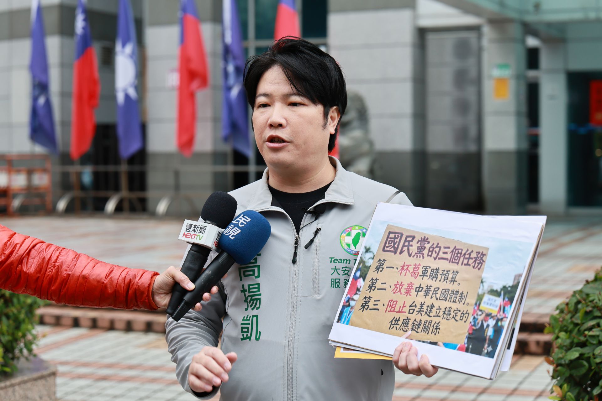 政治人物 高揚凱 2日上午於國民黨中央黨部前受訪，手持標語指出重啟國共論壇的政治風險，痛批國民黨主席鄭麗文親中急統，呼籲捍衛中華民國體制與台灣安全。翻攝畫面