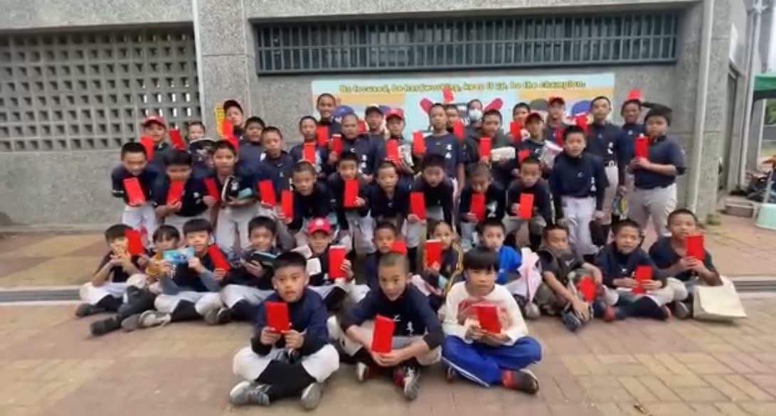 不同年齡層的棒球小將開心展示收到的紅包,象徵年節祝福與社會各界的溫暖支持。