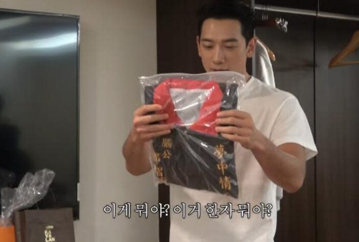 Rain穿上粉絲送的宮廟背心。（圖／翻攝Rain YouTube）