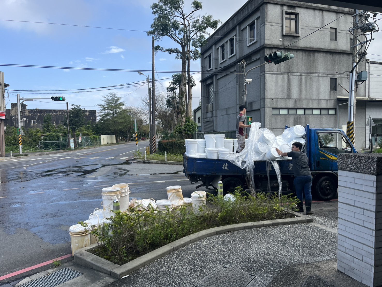 。1輛藍色小貨車行經香中路、東城路口準備左轉時，疑似因後車斗裝載的貨物未綑紮牢固，導致多桶白色儲水桶在轉彎過程中失衡砸向路面。