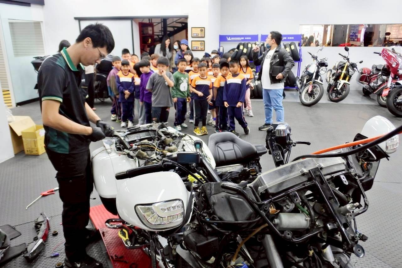 在啟德國際重機車業展示區內，專業人員向互助國小學童介紹重型機車結構與維修知識，讓孩子們近距離認識重機產業。