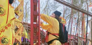 武當道教太玄法師協會主持蕭宴渝攀登刀梯。（圖/中國武當道教太玄法師協會）