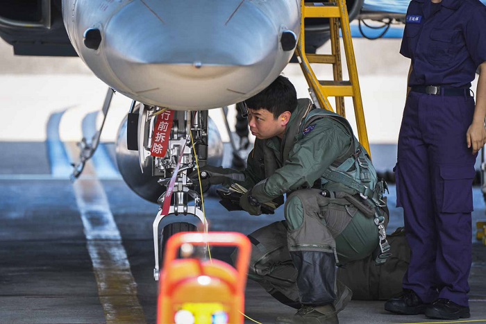 飛行官攜帶任務資料與頭盔前往機庫,與機工長進行起飛前報告與飛機360度檢查。(軍聞社提供)