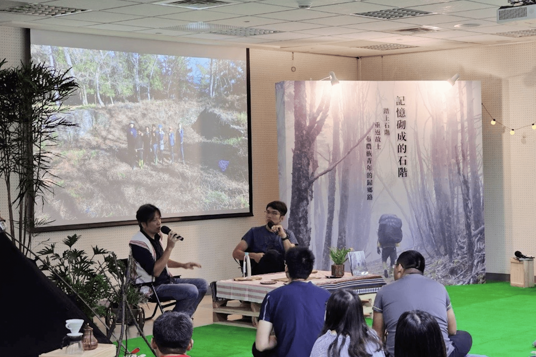 ▲山岳作家雪羊與布農族攝影記者石馬,暢聊與布農青年從花蓮馬遠部落,徒步跋涉到南投丹大老家一同回家的紀實故事。(圖/新北市原民局提供)