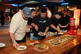 A group of people standing around a table with food on plates AI-generated content may be incorrect.